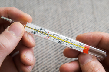 Measuring body temperature with a classic thermometer, health and medicine.
