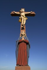 Colored stone crucifix with Mary, against a blue sky, Ringsheim, Baden-W&uuml;rttemberg, Germany, Europe