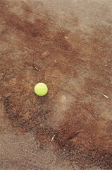 Tennis Ball on Clay Court with Shoe Prints