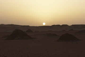 Fototapeta premium Sunset in desert with hills in front