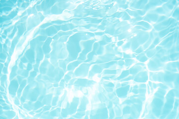 Blue water with ripples on the surface. Defocus blurred transparent blue colored clear calm water surface texture with splashes and bubbles. Water waves with shining pattern texture background.