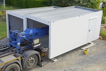 The second half of a prefabricated garage is placed on the strip foundation