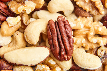 Close-up of assorted nuts, including pecans, cashews, Brazil nuts, and walnuts, showcasing natural textures, earthy tones, and freshness