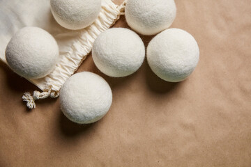 Wool Dryer Balls with Cotton Bag on Brown Paper Background