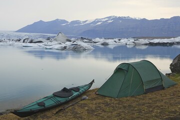 Overnight camp with a tent and a folding kayak beside the Joekulsarlon glacial lake, Iceland, Europe