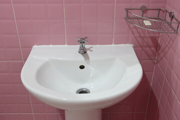 Porcelain sink in bathroom with shelf on wall