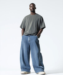 Lookbook, a male model standing in a white studio wearing baggy jeans and an oversized t-shirt, wide-leg denim pants, full-body shot.


