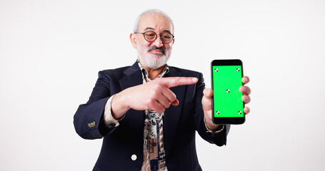 Studio, green screen and mature man with smartphone, space or pointing for presentation of mobile. White background, tips and advertising of web application, tracking markers or display of technology