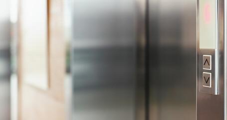 Arrow, button and elevator in office building for up or down direction for arrival at floor of choice. Press, push and select with electronic lift service in corporate workplace for convenience