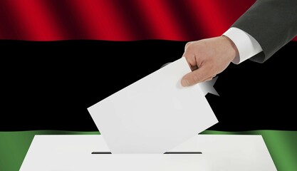 The Libyan flag and the hand with the bulletin about the ballot box