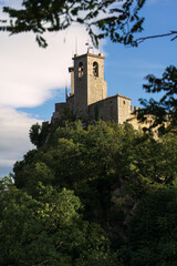 Ancient stone castle on a hill surrounded by trees in San Marino