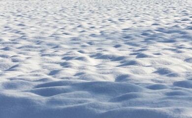 Snow, bumpy ground with light and dark areas