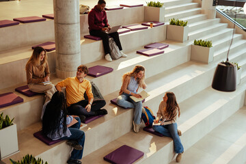 University students studying and chatting on modern bleachers