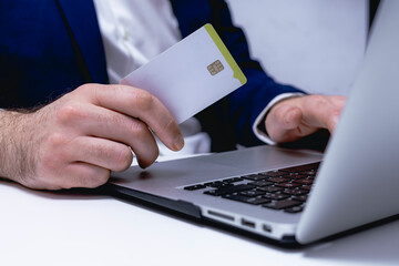 Man holding credit card and using laptop computer. Online shopping concept.