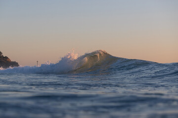 Small wave breaking on the beach shore.