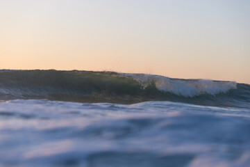 Barrel wave breaking on the beach shore.