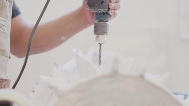 Men drilling in a handcraft sculpture for interior design