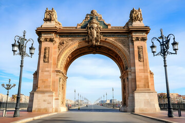 Majestic Arch Stands Tall with Ornate Details, Overlooking a Wide Road and Distant Buildings under a Clear Sky.