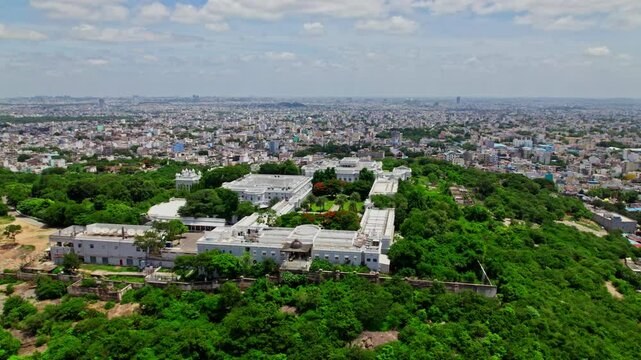 Taj Falaknuma Palace with hyderabad city view, sky and clouds at Engine Bowli, Falaknuma, Hyderabad, Telangana, india. day time, pan shot, drone shot, 4k