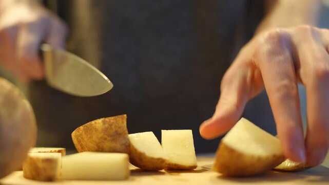 A man cutting potatoes up for dinner