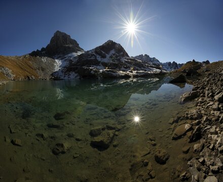 Mountain lake with sun mirroring in front of Alpine peaks, Lake Guffel, Gramais, Lechtal, Reutte, Austria, Europe
