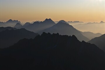 Sunrise with rows of mountains with hazy valleys, Namlos, Reutte, Tyrol, Austria, Europe