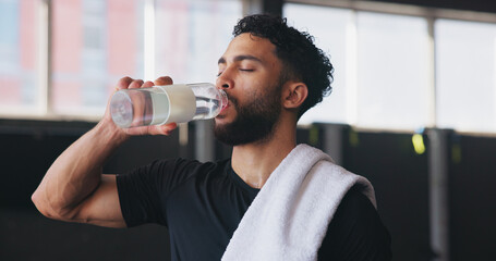 Drinking water, fitness and towel with man in gym for hydration, intense training or workout....