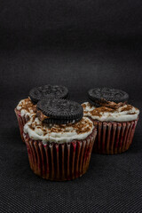 close up of various sweet cupcakes on cake stand isolated on black