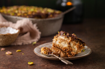 A piece of Dubai chocolate tiramisu with pistachio and chocolate ganache with candle. Italian tiramisu dessert with layers of lady finger biscuit and mascarpone. Professional food photography. 