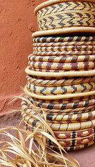 Obraz premium Stack of traditional African handwoven baskets against clay wall