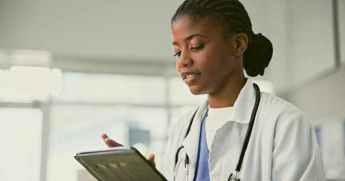 Tablet, doctor and African woman typing, scroll or reading healthcare analytics, medical metrics or clinic stats report. Hospital nurse, surgeon and medic check web research, medicine info or review - Powered by Adobe