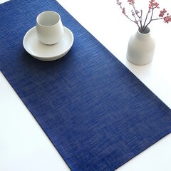 The surface of the dark blue tablecloth with a cup and a white background.