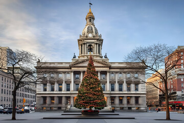 Obraz premium Grand Building Displays Festive Christmas Tree with Ornate Architecture at Dusk