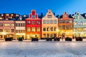 Obraz premium Colorful Buildings illuminate a charming street at twilight, showcasing European architecture.