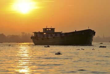 Transport ship at sunset on Mekong River, Mekong Delta, Vietnam, Asia