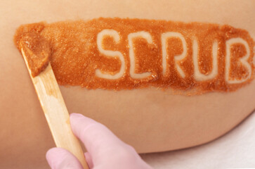 The beautician makes a cosmetic peeling procedure on the thighs of a woman. Spa procedures in a beauty salon.