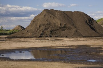 Mound of topsoil in a commercial sandpit after a heavy rainfall, Quebec, Canada, North America