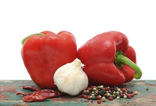 Two red capsicums, garlic and peppercorns