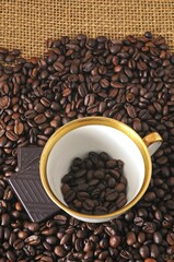 Coffee cup and chocolate on coffee beans
