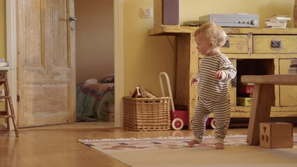 Cute toddler learning to walk, interior shabby chic colourful house