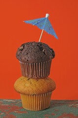 Two muffins, stacked, with an umbrella