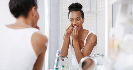 Woman, mirror and flossing teeth in home, orthodontics and cosmetics in bathroom. Female person,...