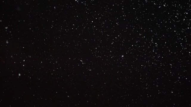 Heavy snowfall at night. Light from street lamps falls on flying snow. Mysterious atmosphere, winter, night.