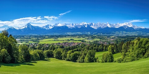 Obraz premium Breathtaking Alpine Panorama: Snow-capped Mountains and Lush Green Valley