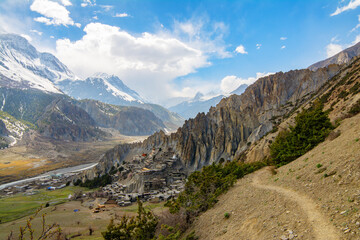 View of Buddhist Bhrakaa or Bhraka Monastery, Marsyangdi river, mountains and rocks in Himalayas, Annapurna Conservation Area, Nepal. Snow capped landscape. Annapurna Circuit Trek. Hiking trekking con