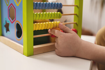closeup hand of child learning to count on colored wooden abacus. Child development and preschool...