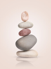tower of smooth pebbles on a light beige background.