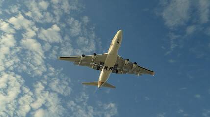 Fototapeta premium Low angle view of an airplane in flight against the sky, perfect for aviation, travel, transportation, and adventure-themed concepts, Generative AI