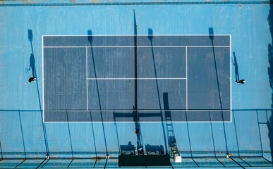 Aerial view of a tennis match on a blue court.