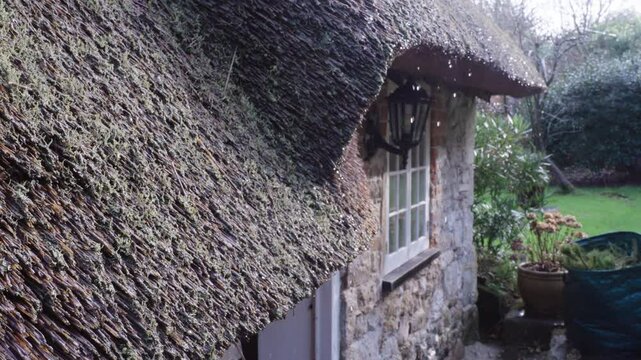 Slow motion of Raindrops falling from Thatch roof of Briary lodge